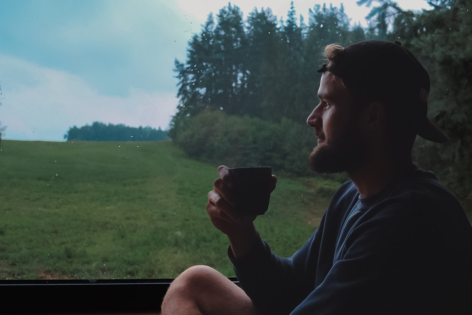 Žmogus žiūrintis pro panoraminį langą
